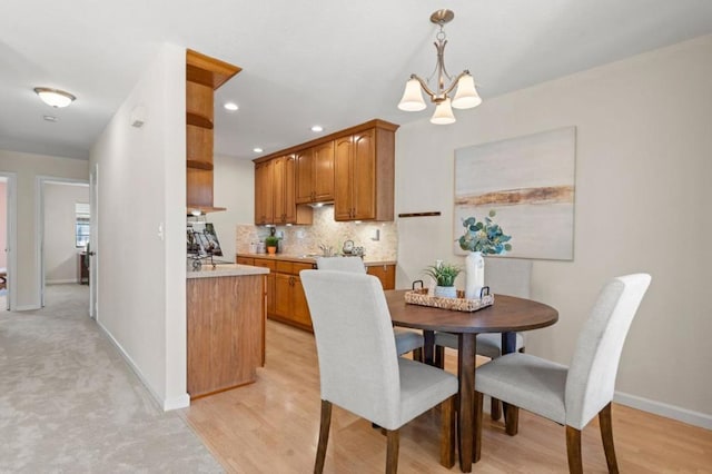 dining space with light wood-type flooring and a notable chandelier