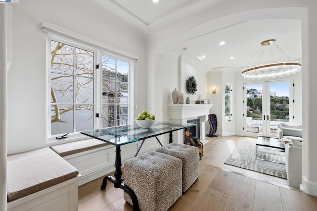 dining area with french doors, a chandelier, and light hardwood / wood-style flooring