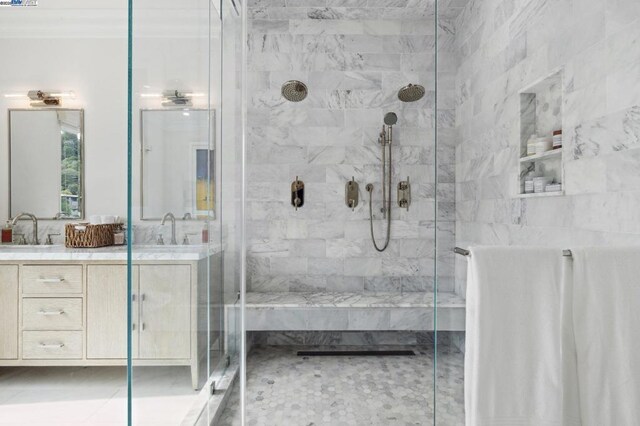 bathroom featuring ornamental molding, a shower with shower door, and vanity