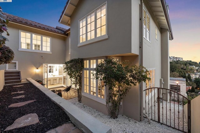 property exterior at dusk featuring a patio area