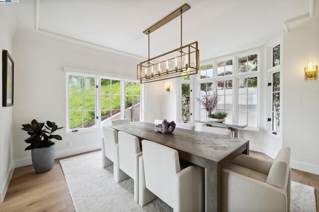 dining area featuring light wood-type flooring and a notable chandelier