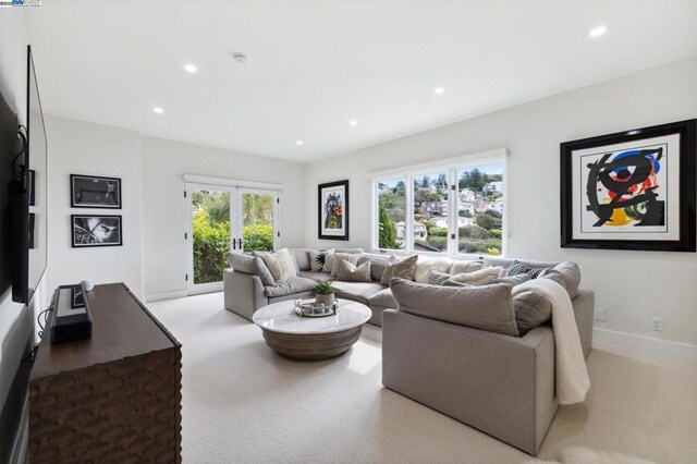 living room with plenty of natural light, light colored carpet, and french doors