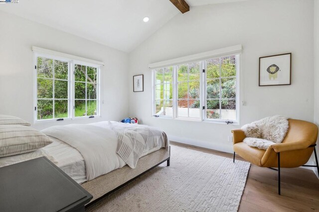 bedroom with ceiling fan, vaulted ceiling with beams, and light hardwood / wood-style floors