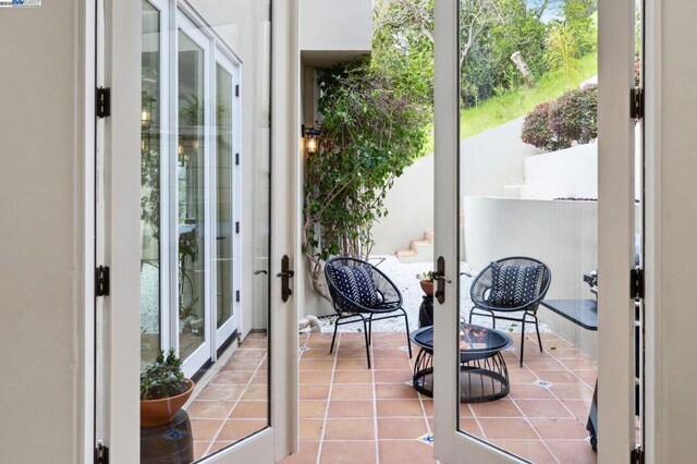 doorway to outside featuring light tile patterned floors and french doors