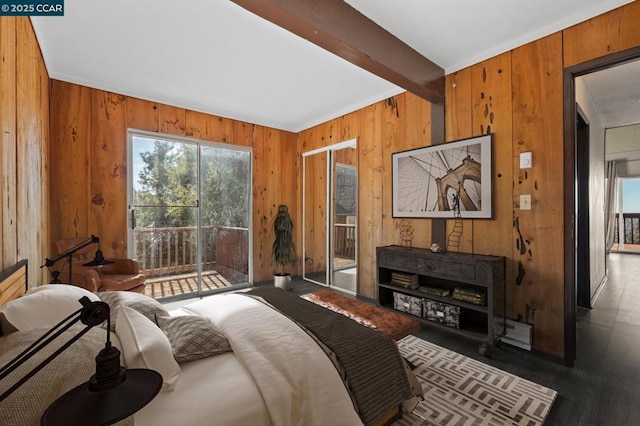 bedroom featuring wood walls and beam ceiling