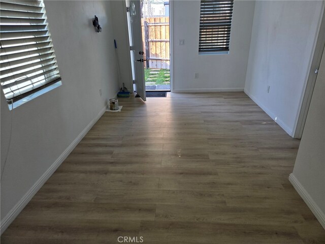 empty room with hardwood / wood-style floors and a wealth of natural light