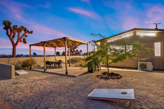 yard at dusk featuring a patio area and ac unit