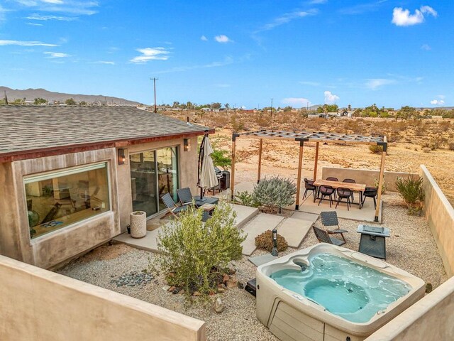 view of swimming pool featuring a mountain view, a patio area, and an outdoor hot tub