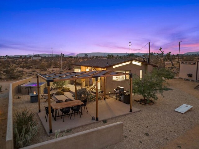 patio terrace at dusk featuring a grill and a jacuzzi