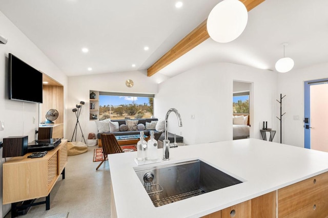 kitchen featuring sink, pendant lighting, a healthy amount of sunlight, and vaulted ceiling with beams