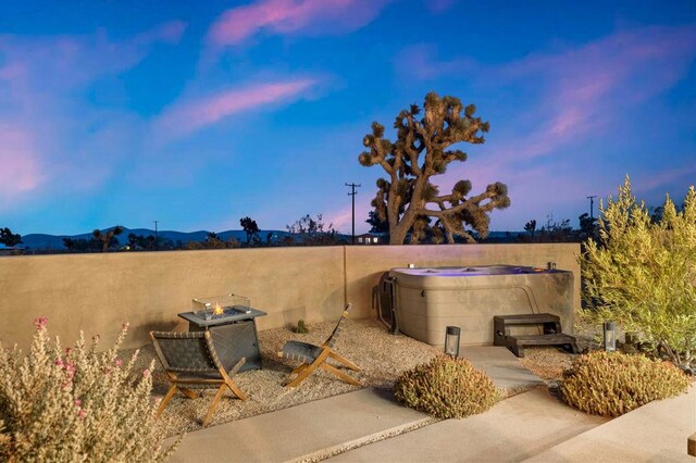 exterior space with a mountain view and a hot tub