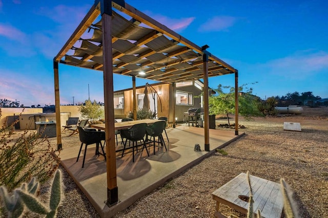 patio terrace at dusk featuring a pergola