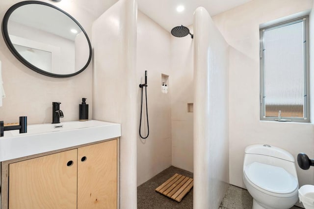 bathroom featuring toilet, a shower, and vanity