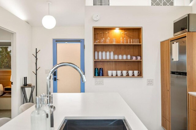 kitchen featuring decorative light fixtures, stainless steel fridge, and built in features