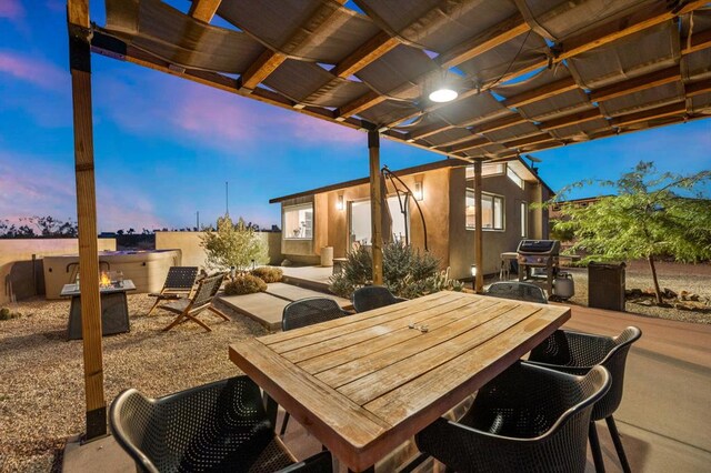 patio terrace at dusk with grilling area and a pergola