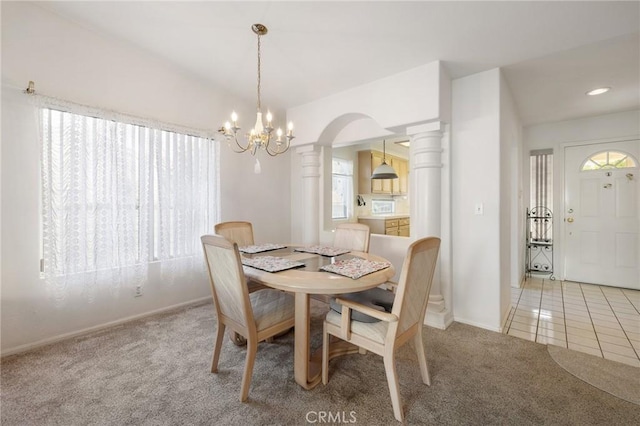 dining area featuring light colored carpet, an inviting chandelier, ornate columns, and a healthy amount of sunlight