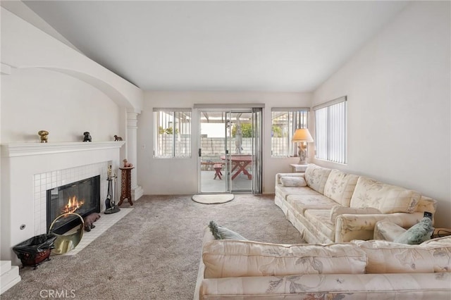 carpeted living room with lofted ceiling and a fireplace