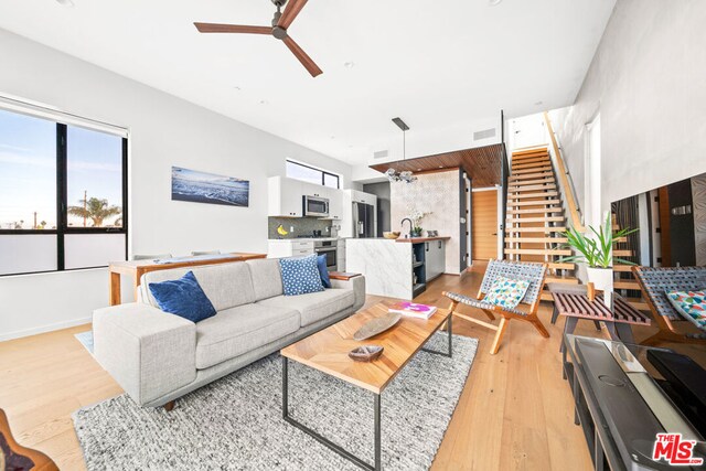 living room featuring ceiling fan and light hardwood / wood-style floors