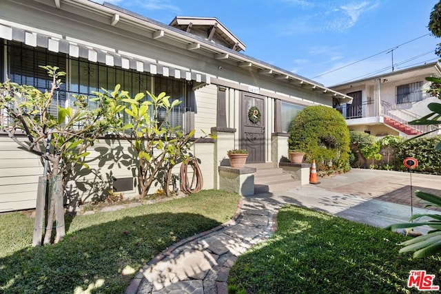 entrance to property with a lawn