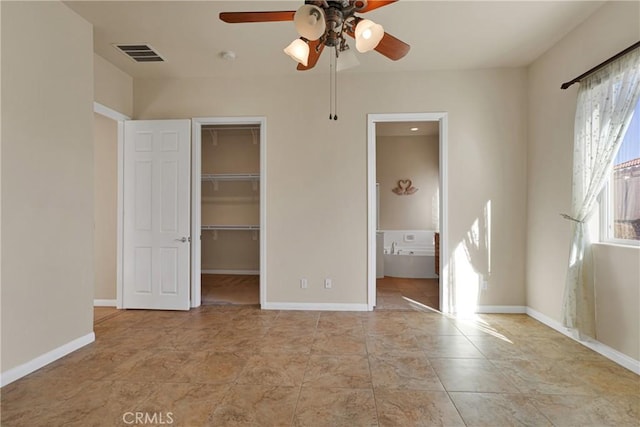 19269 Galloping Hill Rd, Apple Valley, CA 92308 - unfurnished bedroom with a walk in closet, baseboards, a closet, ensuite bathroom, and ceiling fan