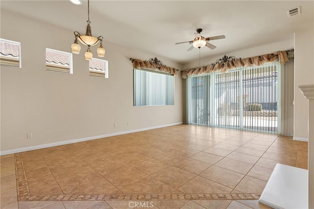 tiled empty room featuring ceiling fan with notable chandelier