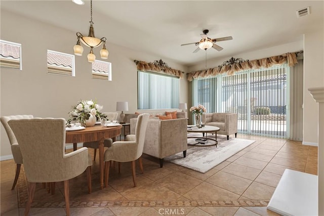 tiled dining space featuring ceiling fan with notable chandelier