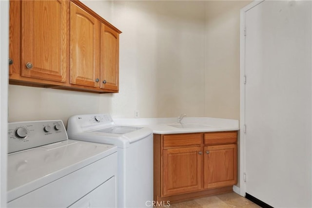 laundry room featuring cabinets, light tile patterned floors, independent washer and dryer, and sink