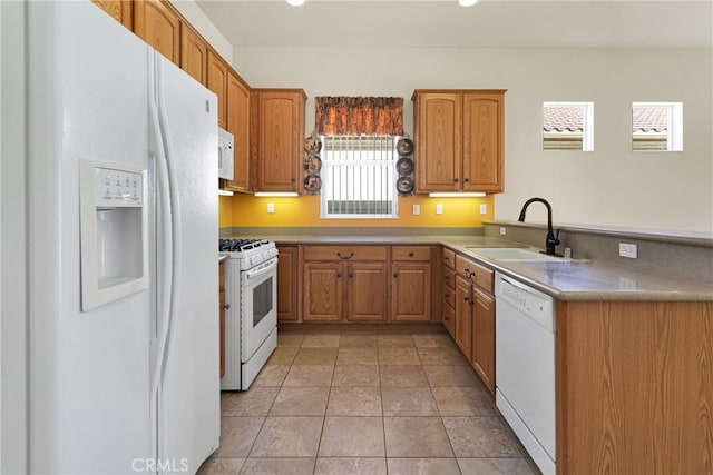 kitchen with light tile patterned flooring, sink, kitchen peninsula, and white appliances