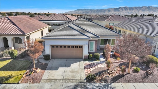 19269 Galloping Hill Rd, Apple Valley, CA 92308 - view of front of house featuring a tile roof, a garage, concrete driveway, stucco siding, and a mountain view