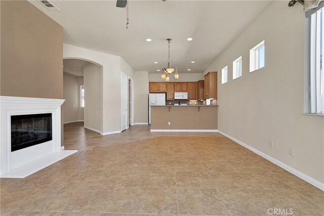 19269 Galloping Hill Rd, Apple Valley, CA 92308 - unfurnished living room with recessed lighting, healthy amount of natural light, light tile patterned flooring, arched walkways, and a ceiling fan