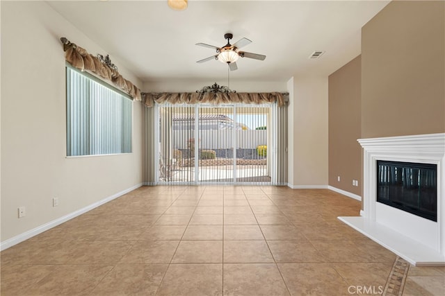 19269 Galloping Hill Rd, Apple Valley, CA 92308 - unfurnished living room featuring a ceiling fan, light tile patterned floors, baseboards, and a glass covered fireplace
