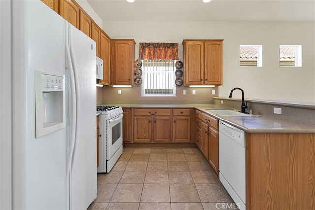 19269 Galloping Hill Rd, Apple Valley, CA 92308 - kitchen featuring white appliances, a sink, a peninsula, brown cabinetry, and light countertops