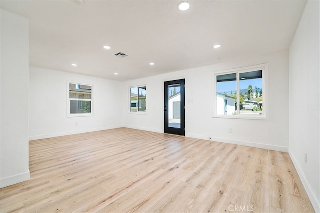 unfurnished room featuring light wood-type flooring and plenty of natural light