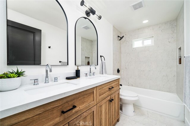 full bathroom with toilet, vanity, and tiled shower / bath combo