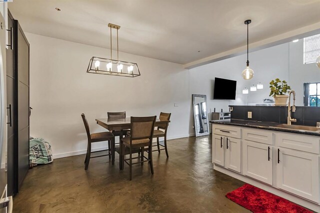 dining space featuring sink and a chandelier