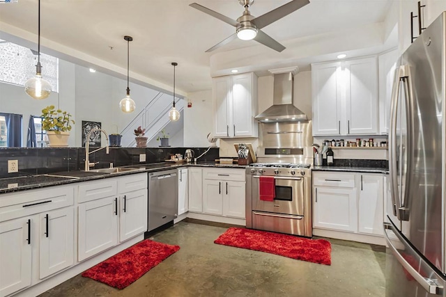 kitchen featuring pendant lighting, white cabinetry, appliances with stainless steel finishes, and wall chimney range hood