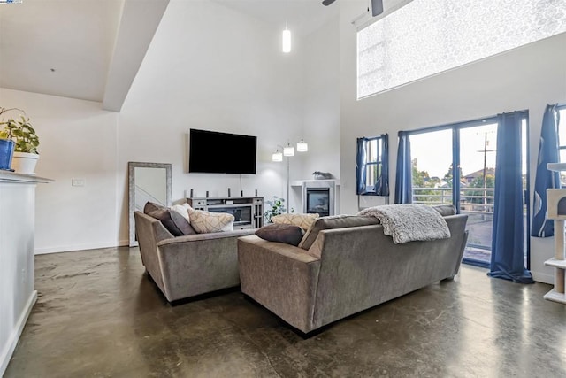 living room featuring ceiling fan and a towering ceiling