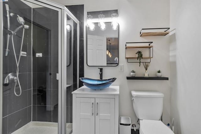 bathroom with vanity, a shower with shower door, and toilet