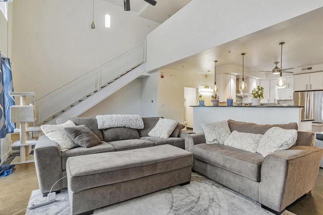 living room featuring ceiling fan and a high ceiling