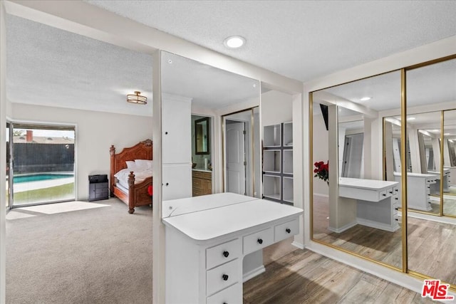 bathroom featuring wood-type flooring and a textured ceiling