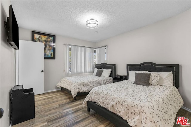 bedroom with wood-type flooring and a textured ceiling