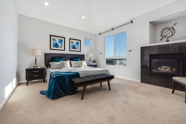 carpeted bedroom featuring a tiled fireplace