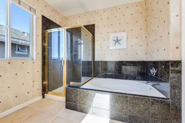 bathroom featuring plus walk in shower, a healthy amount of sunlight, and tile patterned flooring