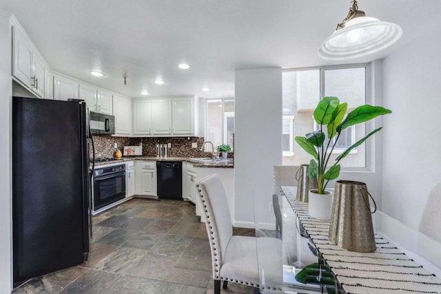 kitchen featuring sink, pendant lighting, white cabinets, and black appliances