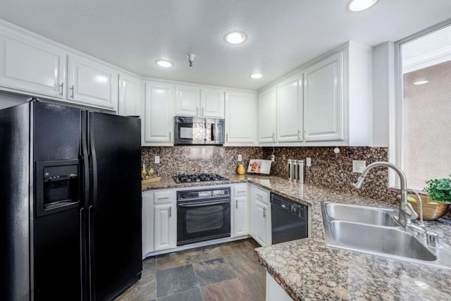 kitchen featuring sink, backsplash, black appliances, and white cabinets