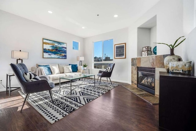 living room featuring dark hardwood / wood-style floors and a tiled fireplace