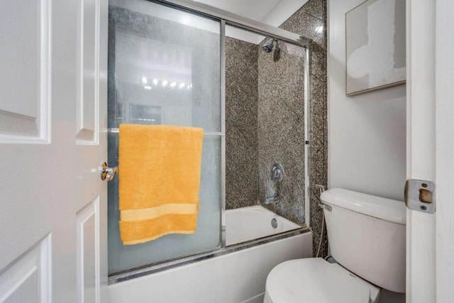 bathroom with shower / bath combination with glass door and toilet