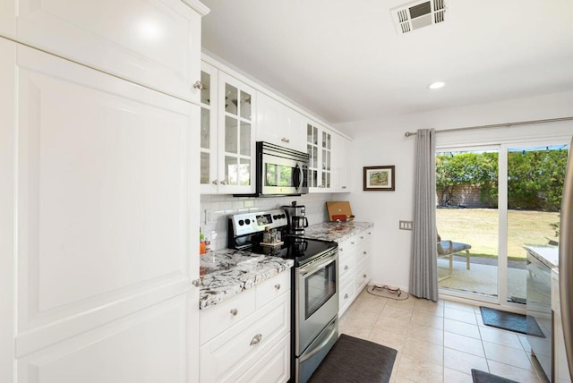 kitchen with backsplash, white cabinetry, stainless steel appliances, light tile patterned floors, and light stone counters