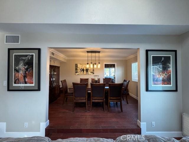 dining room featuring ornamental molding and dark wood-type flooring