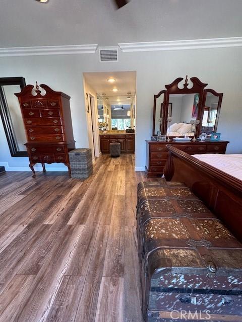 bedroom featuring wood-type flooring and crown molding